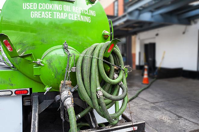 a technician pumping a grease trap in a commercial building in Gardena